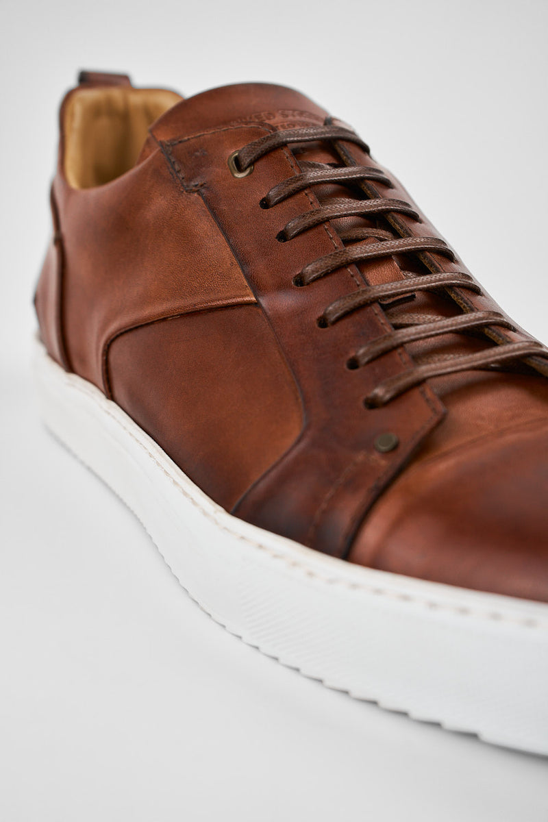 SKYE cognac studded patina sneakers.